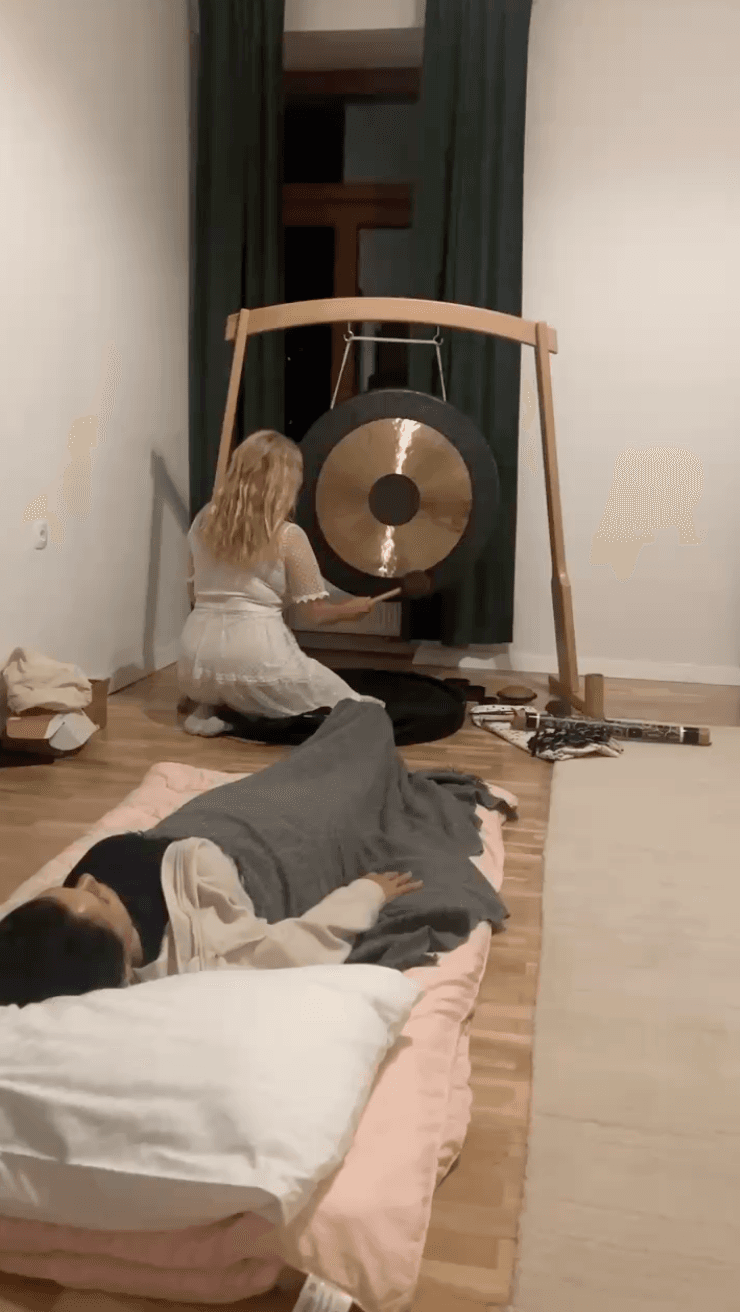 Anamarija svira gong dok klijenti leže na prostirkama